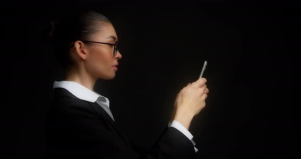 Business Woman Stands in Profile Communicates in Messenger
