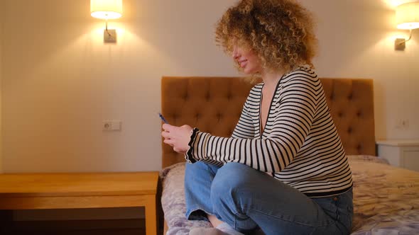 Curly white female using smartphone for internet communication in 4k stock video alt