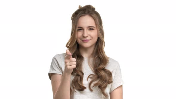 Portrait of Cheerful Nice Woman 20s in Casual Tshirt Gesturing Finger on Camera Meaning Hey you Over alt