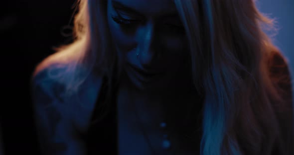 Close up of a young female tattoo artist focusing while giving someone a tattoo alt