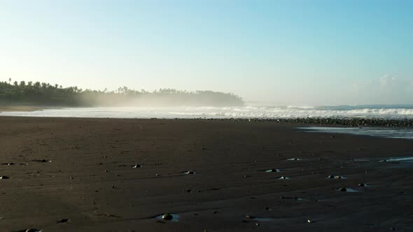 Moving across a black sand beach at sunrise