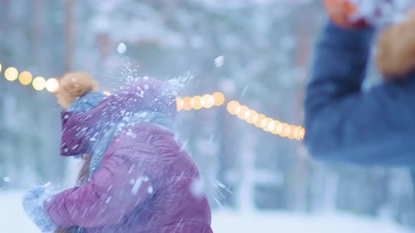 Joyful Woman Throws Snow with Boyfriend on Skating Rink