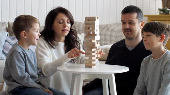Family is Playing in Wooden Tower at Home