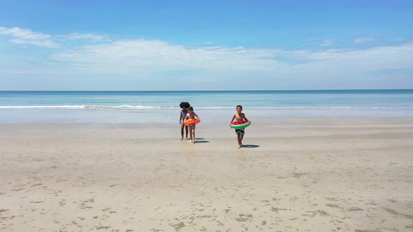 4K Group of Diversity children playing on tropical beach together on summer vacation at the sea
