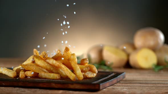 Super Slow Motion Shot of Adding Salt on Fresh French Fries at 1000Fps. alt