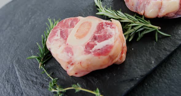 Close-up of sirloin chops and rosemary on chopping board alt