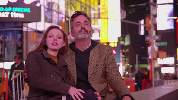 Couple sitting together talking in Times Square, New York City