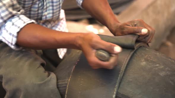 Black Man's Hands Cut Black Wheel Tires in Stripes with Knife Recycle Materials