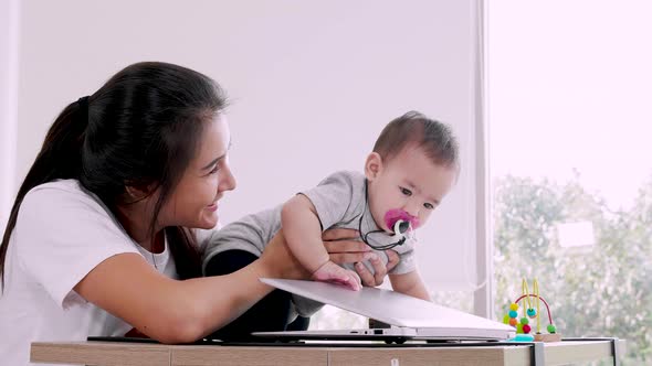 Mother freelance work at home. Modern motherhood, little baby girl. online education of children alt