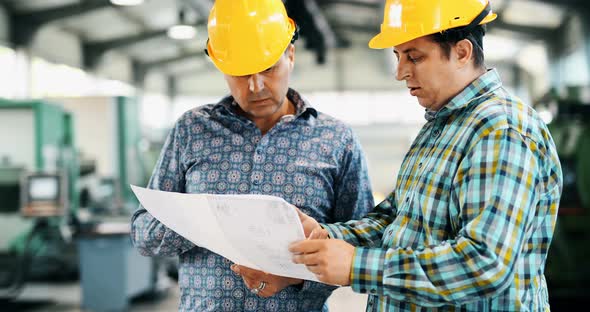 Team Of Engineers Having Discussion In Factory alt