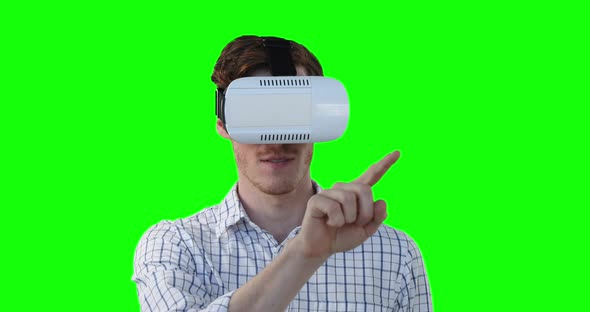 Caucasian man wearing a VR headset on green background