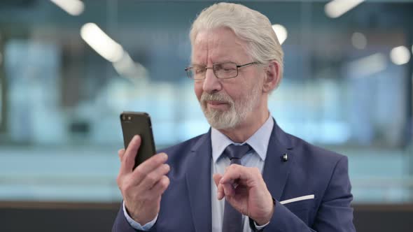 Portrait of Old Businessman Using Smartphone alt