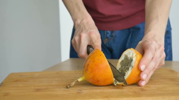 Fresh Organic Ripe Granadilla or Yellow Passion Fruit Cut in Half on a Wooden Board alt