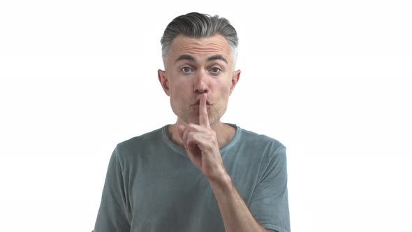 Handsome Middleaged Guy with Grey Hair and Bristle Asking to Keep Quiet Whispering and Shushing Need alt