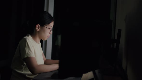 Asian woman freelance wearing glasses typing keyboard.