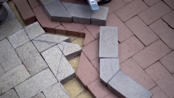 As camera turns and rotates around the action, a stone mason uses a level as a straight edge to mark alt