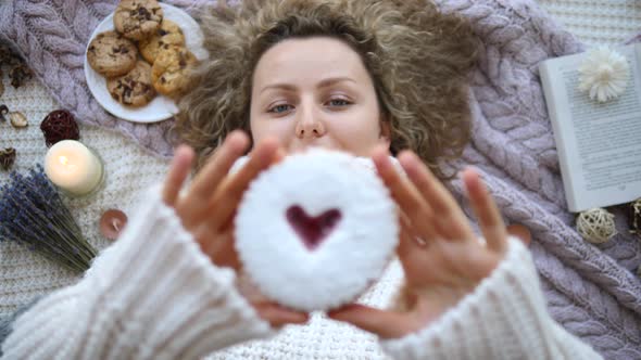 Woman In Knitted Sweater Showing Valentines Cookie alt