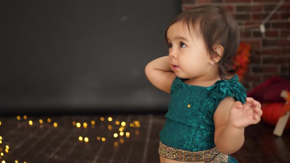 Baby Girl Standing in Studio in Green Dress alt