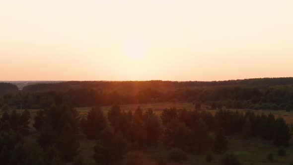 Aerial View of a Car Driving on the Road at Sunset alt