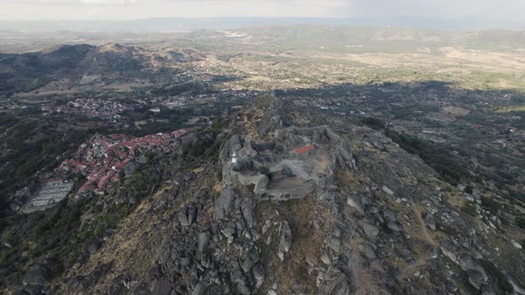 Ruins of Monsanto hilltop castle with panoramic views, drone orbit