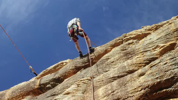 Mountaineer rappelling down the hill with the help of rope 4k alt