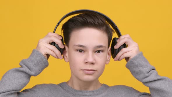 Teen Boy Wearing Headphones Listening To Music Studio Shot alt
