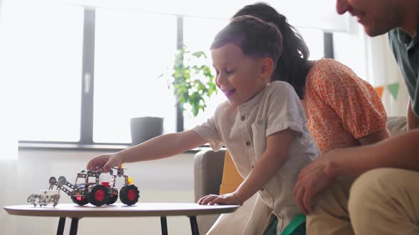 Happy Family Playing with Birthday Present at Home alt