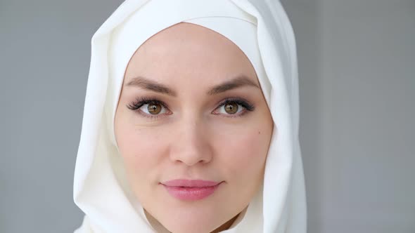 Attractive Muslim Woman Wearing Hijab Is Looking at Camera and Smiling alt