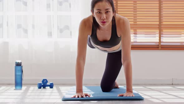 Athletic Healthy Asian young woman in sportswear workout legs excercise at home alt
