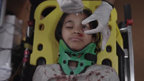 Paramedic Checking Pupils of Indian Girl in Ambulance alt