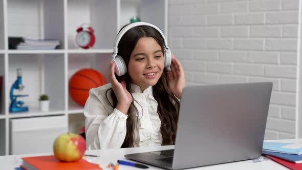 Happy Child in Headphones Study at School Online Lesson with Laptop Showing Thumb Up Education