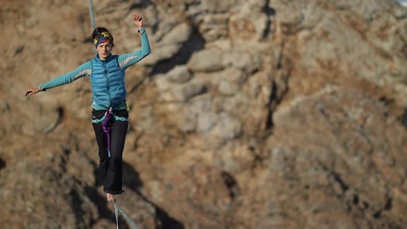 A Young Woman Is on the Slackline at High Altitude