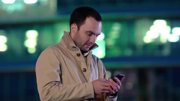 Handsome Adult Man Sending a Text Message While Standing in the City Street, Business Man Reading alt
