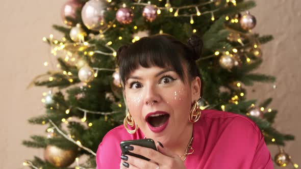 Amazed lucky christmas woman using mobile phone looks and sees the message. Wow! alt