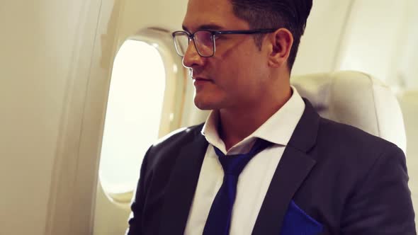 Young Businessman Using Laptop Computer in Airplane alt