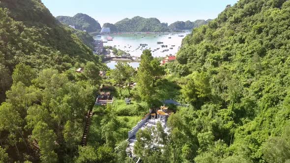 Drone Flies Over Green Hills Across Town To Wide Ocean Bay alt