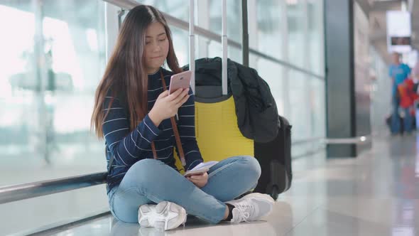 Young female traveler feel boring to waiting someone at airport