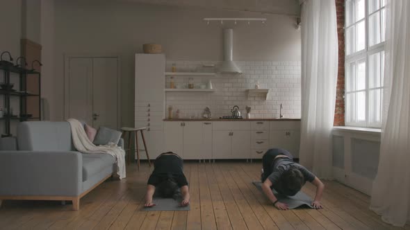Man and Woman Practicing Yoga at home alt