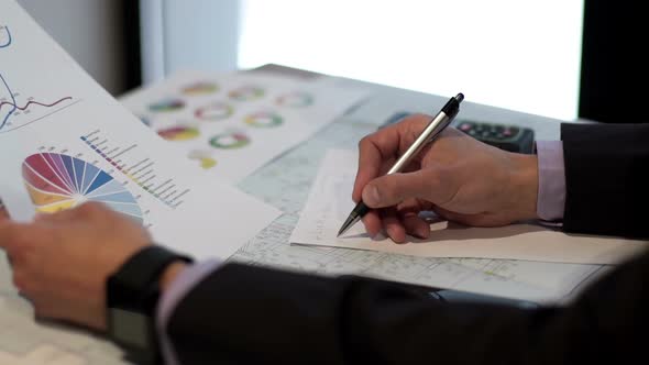 Businessman Works with the Drawings and Graphs alt