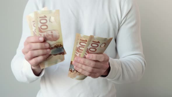 Man counting many Canadian Dollar Currency 100 Bills