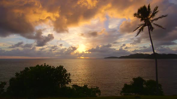 View of a scenic tropical island in Fiji at sunset. alt
