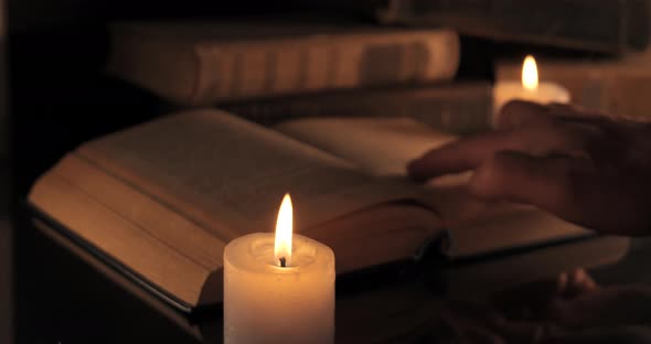 A Man Reads and Turns Over the Yellow Pages of an Old Book alt