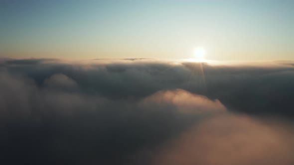 Flight above fog clouds at sunrise alt