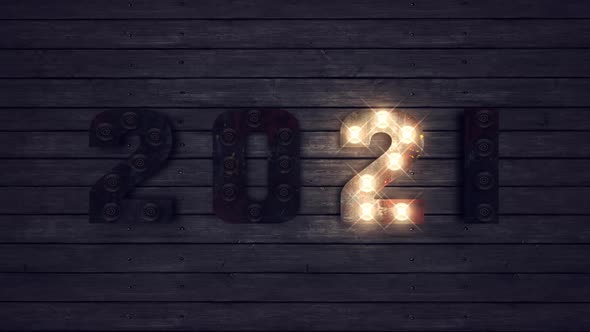 2021 Happy New Year light bulbs sign on wooden background. New year concept.
