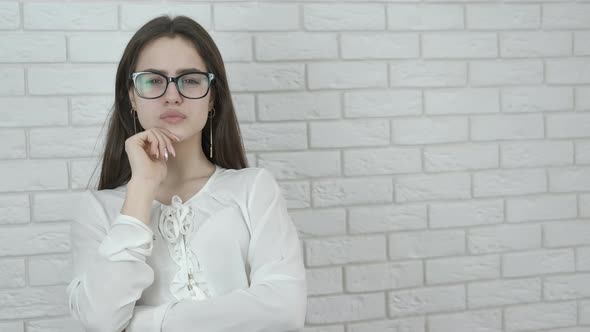 Beautiful girl in glasses thinks. alt