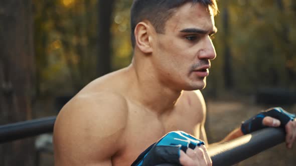 Resting time. Tired sporty man resting after training in the forest gym, outdoors. Close up