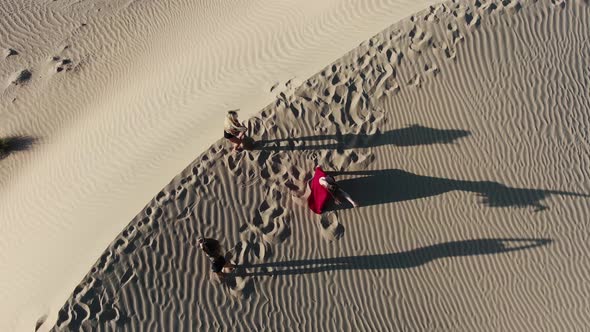 Top View on Three Young Women Dancing in the Desert Sand Dune Rub Al Khali alt