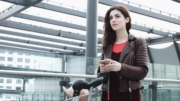 Young Adult Female on smart phone and waiting in airport