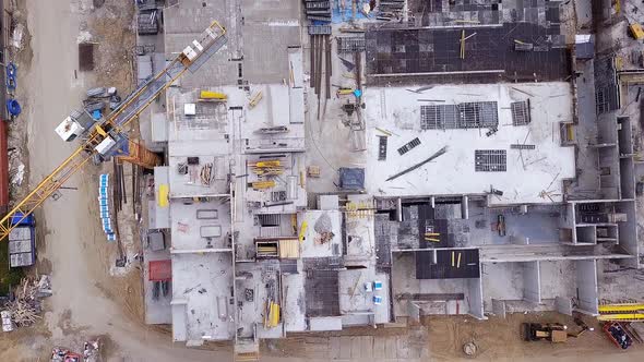 Construction of a residential building. Cranes and constuction site. Drone footage. Lookdown flyby s alt