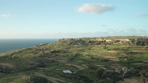 AERIAL: Green High Rugged Cliffs Overseeing Mediterranean Sea Washing Coastline in Malta